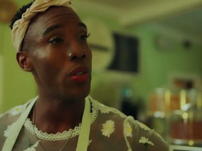 Ernest Pierce is wearing a dress with white flowers designed on it.